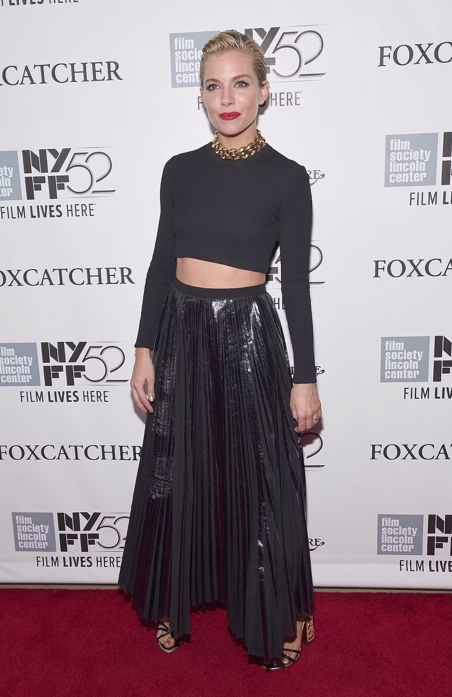 Sienna Miller showing off her toned waist in a black cropped top and matching high-waisted maxi skirt at the Foxcatcher film premiere.