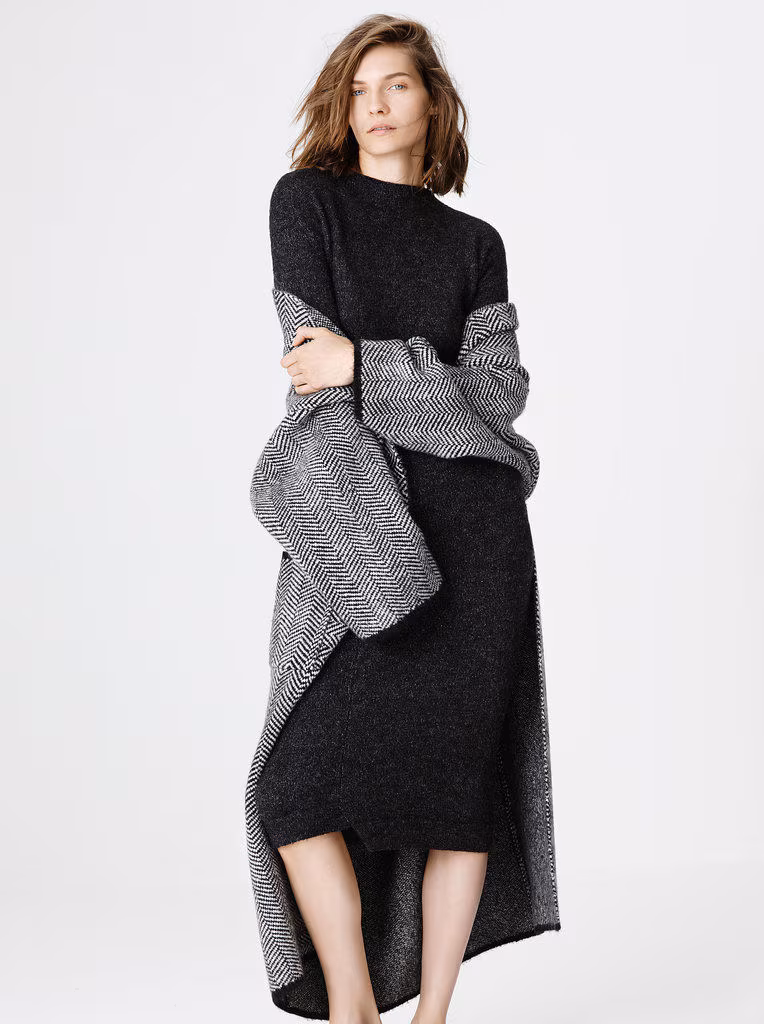 Model wearing a black knit dress and herringbone coat from Zara 2014.