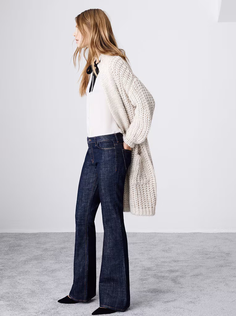 Model wearing a chunky cream cardigan and flared jeans from Zara 2014.