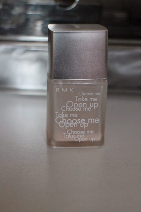 Close-up of the RMK Make-Up Base glass bottle with a silver cap.