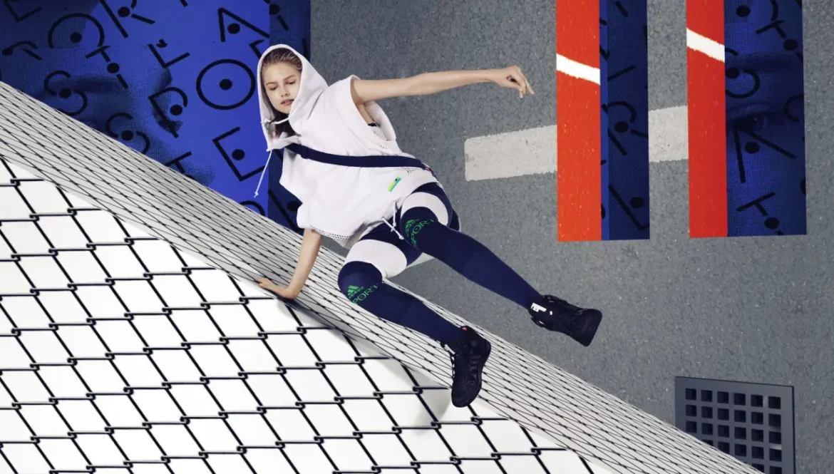 Model wearing oversized white hooded cape and cobalt blue knee socks by Adidas StellaSport