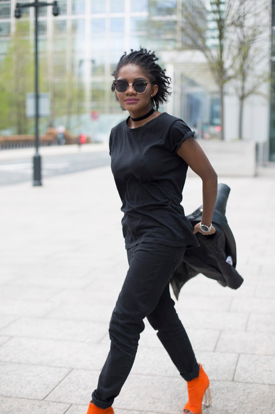 Full-length street style portrait wearing high-waisted black slim jeans, an all-black top, and a black leather biker jacket in London